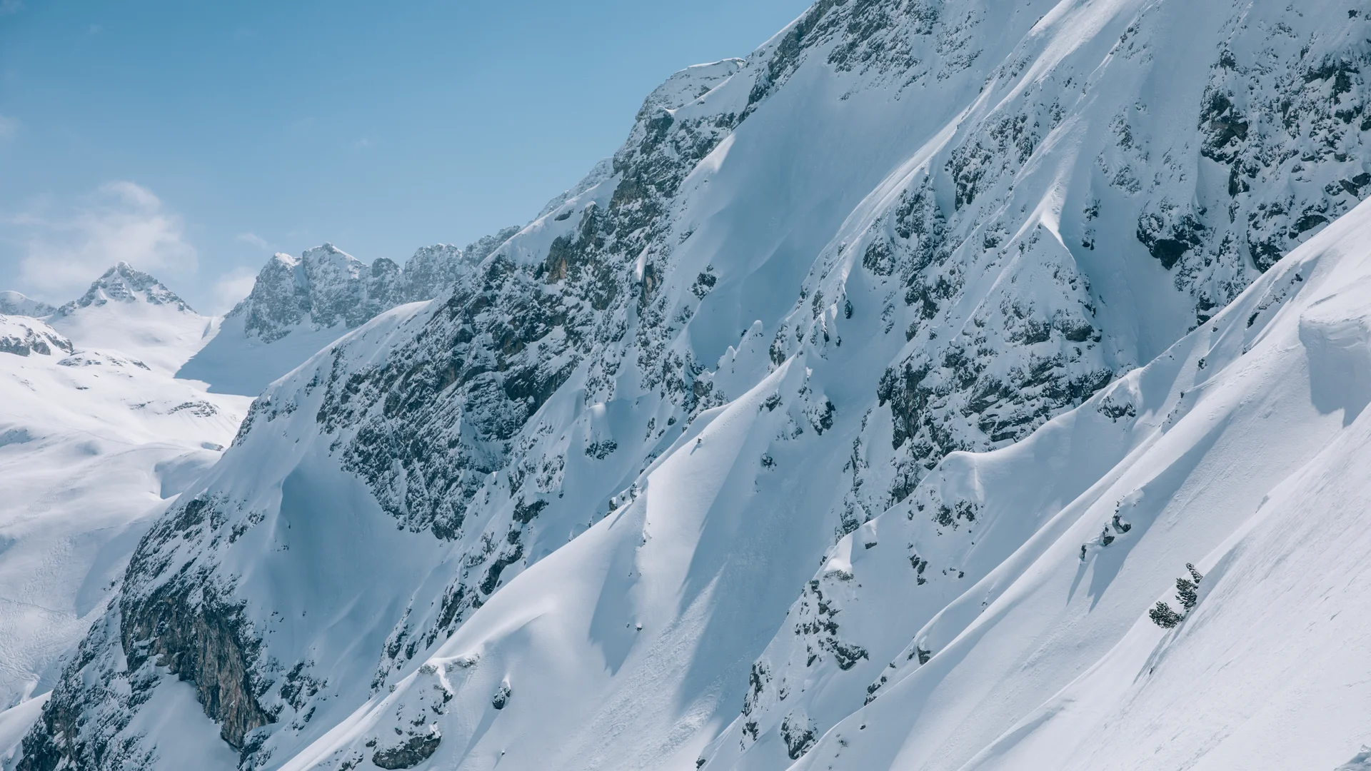 Hotel in Lech am Arlberg mit Ski-in/Ski-out | Hotel Panorama Verschneite steile Berggipfel unter blauem Himmel