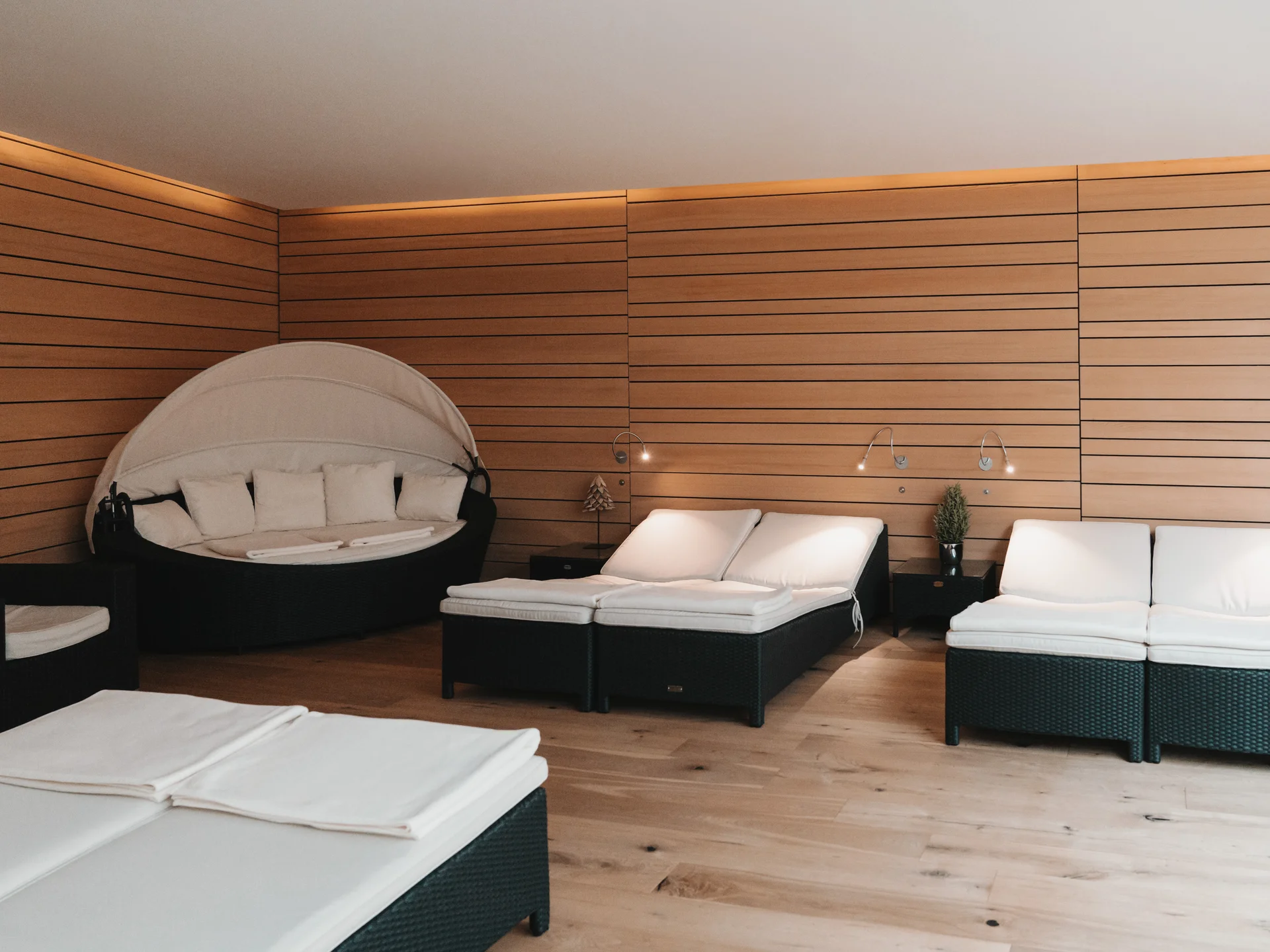 Hotel in Lech am Arlberg mit Ski-in/Ski-out | Hotel Panorama Ruheraum mit weißen Liegen und einer runden Kuschelliege vor holzverkleideten Wänden