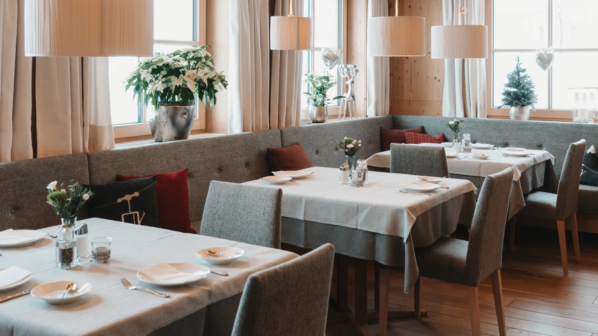 Hotel in Lech am Arlberg mit Ski-in/Ski-out | Hotel Panorama Gemütlicher Gastraum mit gedeckten Tischen, Polsterstühlen und großen Fenstern
